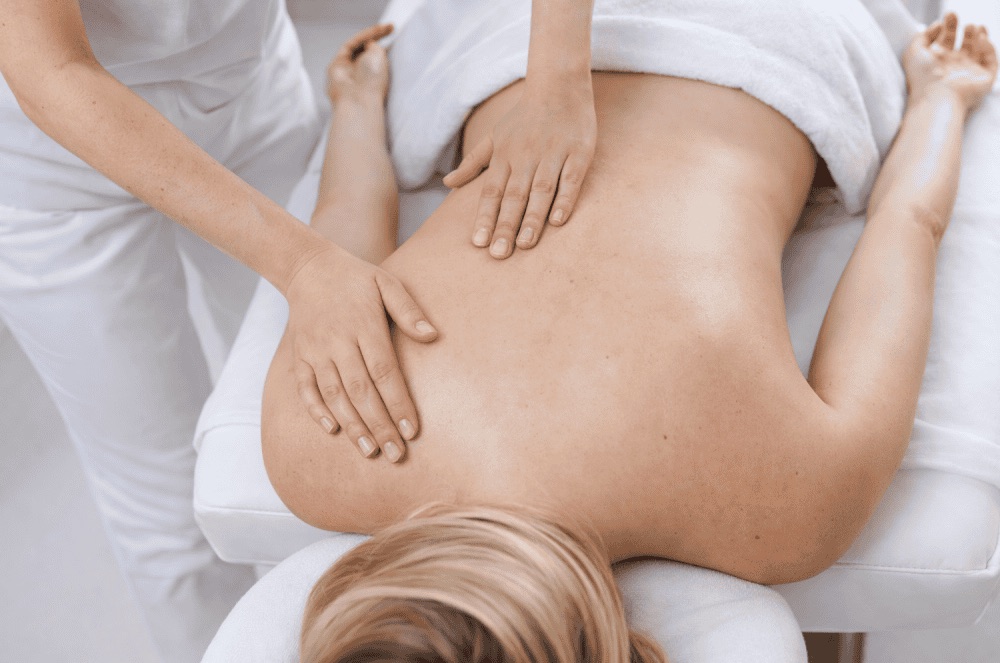 Therapist massaging a client's back at SOMA Healing Spa